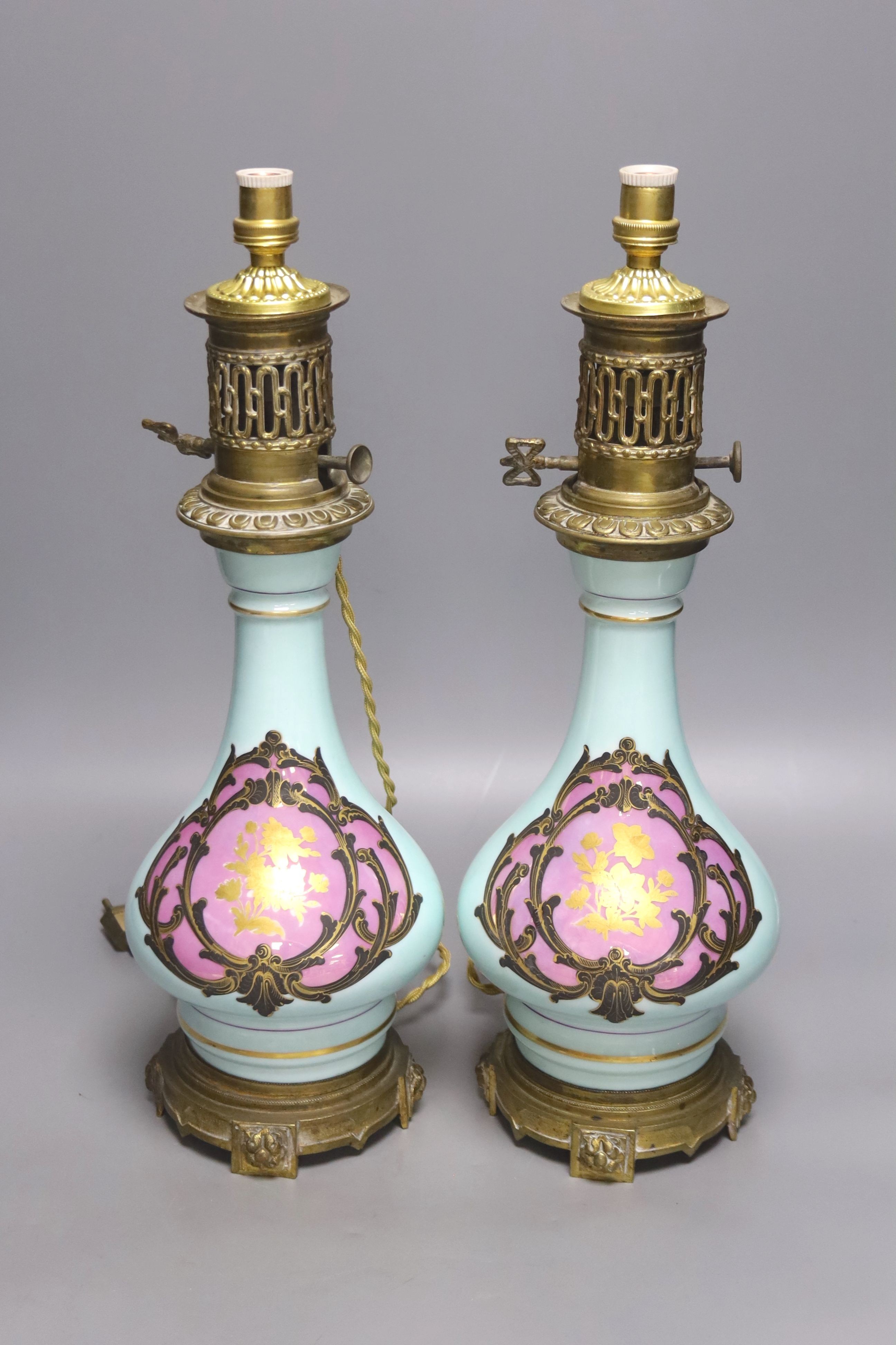 A pair of Napoleon III late 19th century porcelain and ormolu mounted oil lamps, height 40cm